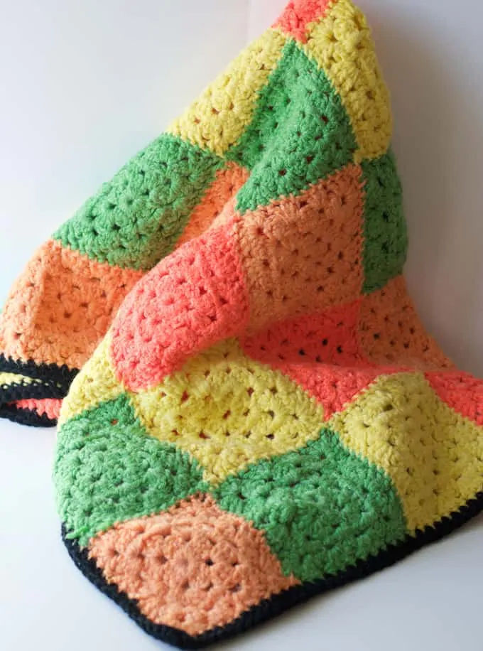 Granny square afghan in orange, yellow, green with black trim