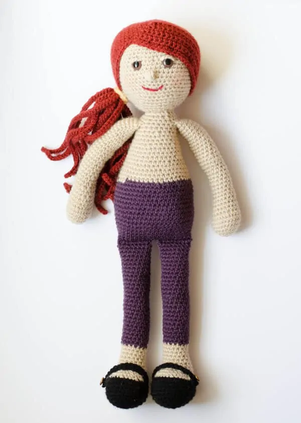 crochet rag doll with auburn hair and purple pants