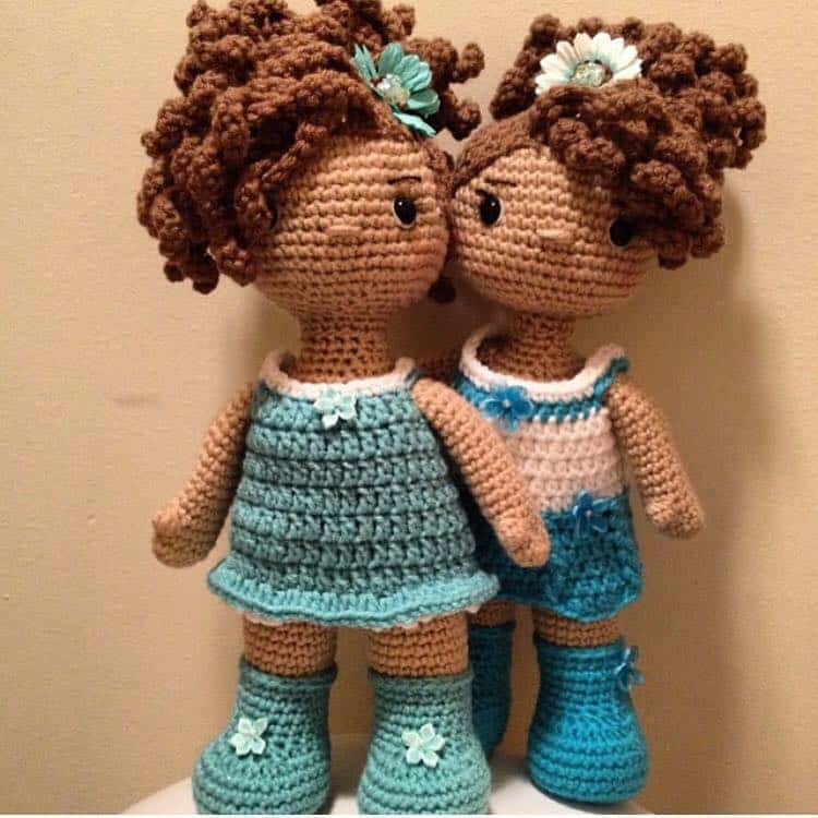 Two crochet dolls with brown curly hair and blue outfits