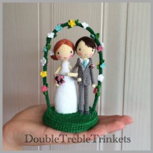 crochet bride and groom under arch with flowers