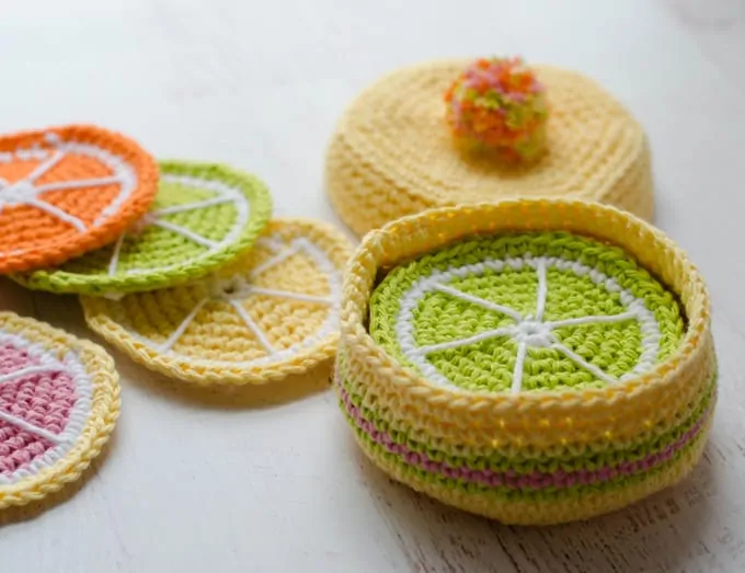 Crochet Citrus coasters in yellow, green, orange, pink and white in a crochet round box