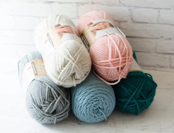 how much yarn to crochet a blanket: ivory, pink, gray, blue and teal yarn