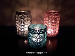 crochet mason jar covers with lit candles inside the jars