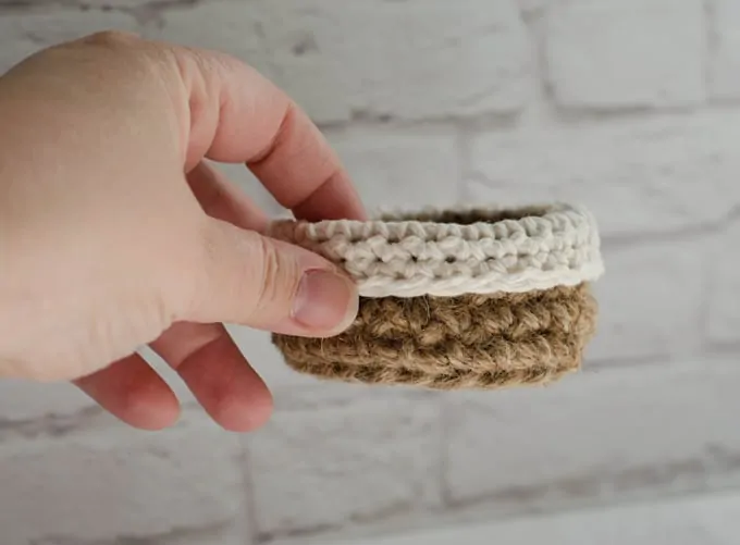 Hand holding mini jute crochet basket