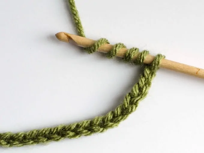 Triple Treble Crochet stitch in progress with green yarn and wood hook
