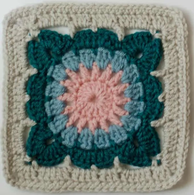 crochet afghan square in pink, blue, gray and ivory yarn