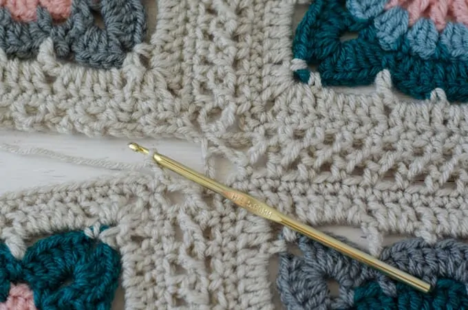 flat braid crochet join 4 squares together with ivory, blue, teal and pink yarn and gold hook