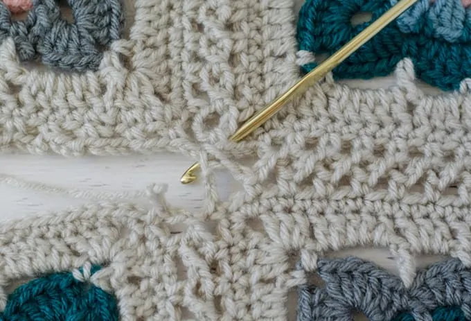 flat braid crochet join 4 squares together with ivory, blue, teal and pink yarn and gold hook