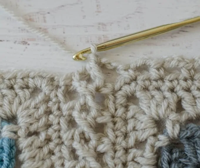 Crochet afghan squares in ivory being joined with flat braid join technique