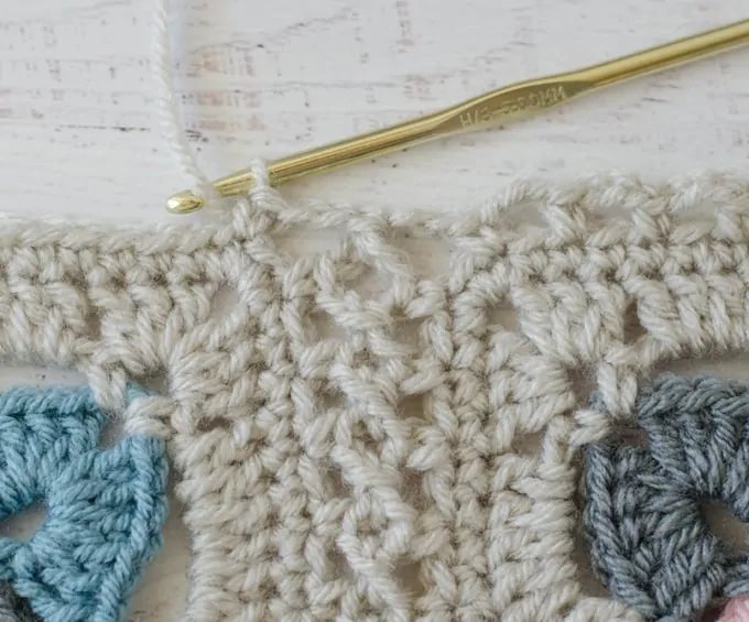 Ivory crochet afghan square with gold crochet hook 