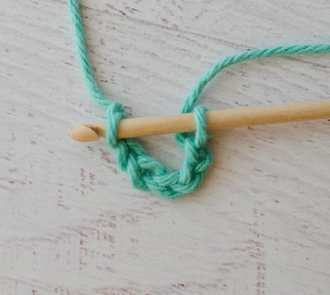 Joining a crochet chain in green yarn with wood hook
