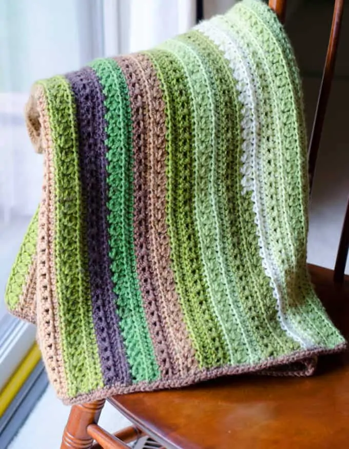 Green and brown Fields and Furrows Crochet Afghan on a chair