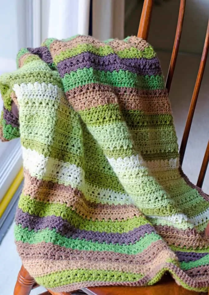 Green and brown Fields and Furrows Crochet Afghan on a chair