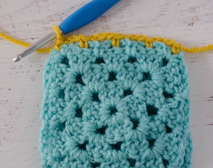 Start of Crochet Faux Braid Join worked in yellow yarn on blue granny square
