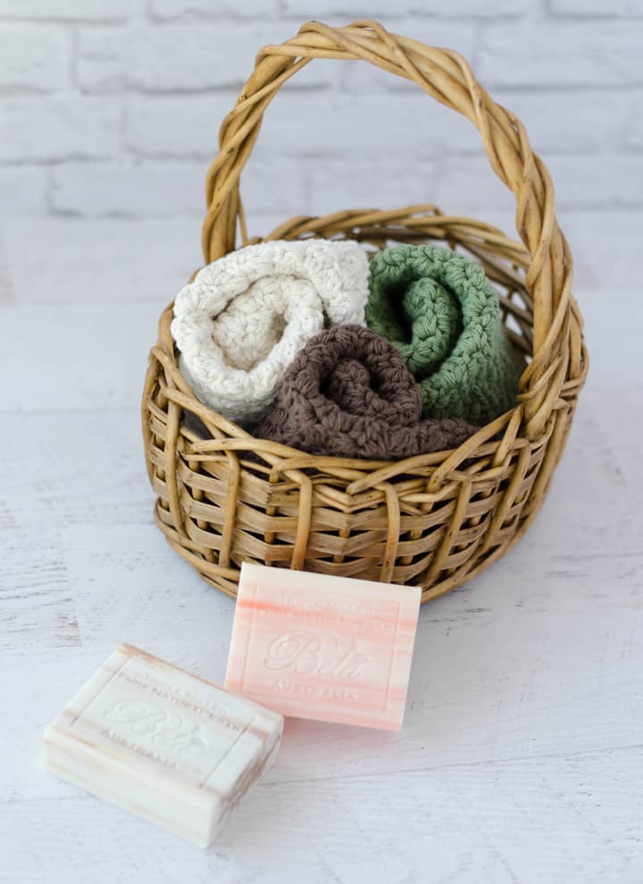 crochet dishcloths in ivory, green and brown in basket with soap