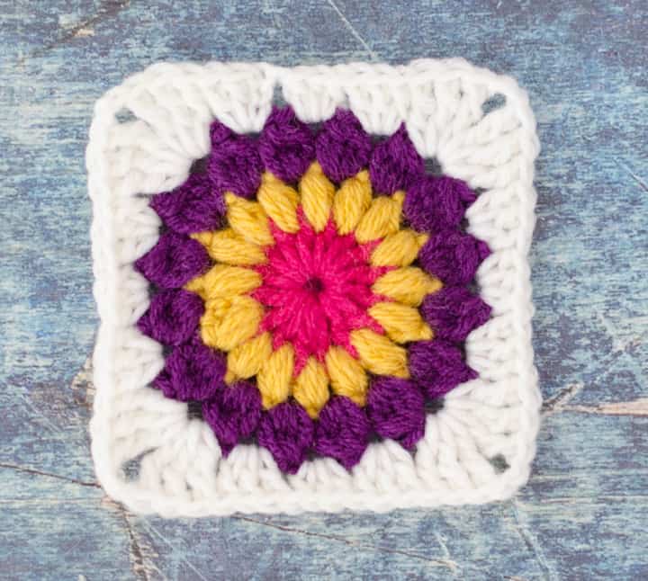 Sunburst Granny Square in pink, yellow, purple and white yarn