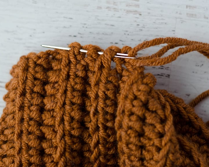 sewing needle sewing up a crochet hat