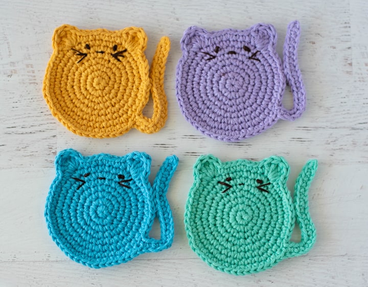 Crochet cat shaped coasters with embroidered features