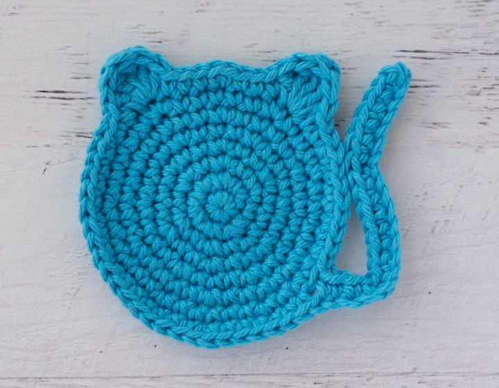 blue crochet coaster in the shape of a cat