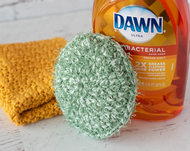 green crochet dish scrubber, yellow dishcloth and dish soap