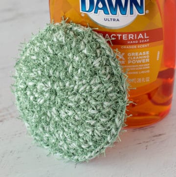 green crochet dish scrubber with dish soap