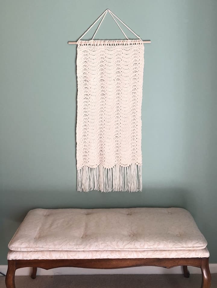 crochet wall hanging over bench