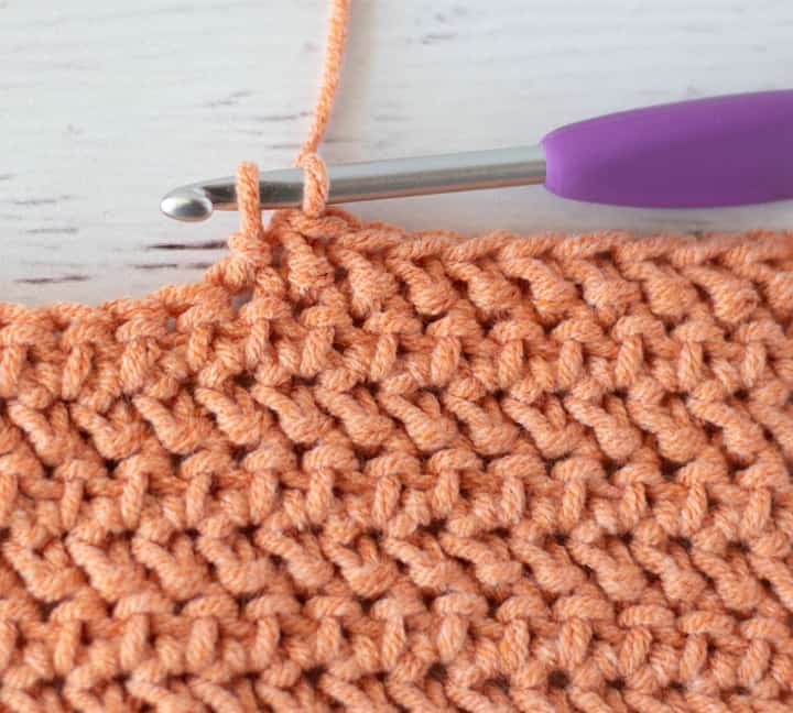 close up of herringbone crochet stitch in orange color yarn