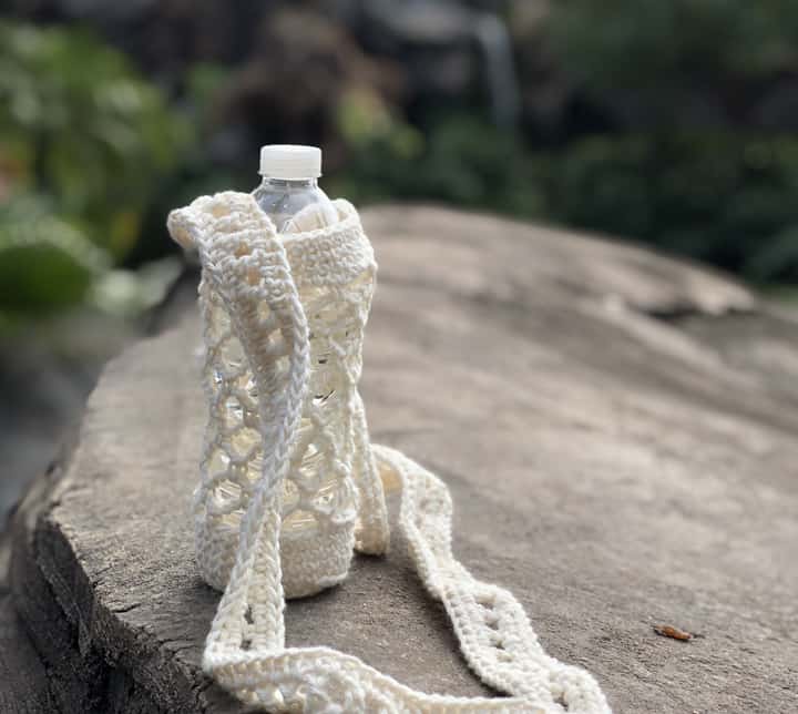 Water bottle in crochet holder on rock