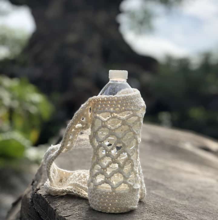 Water bottle in crochet holder on rock