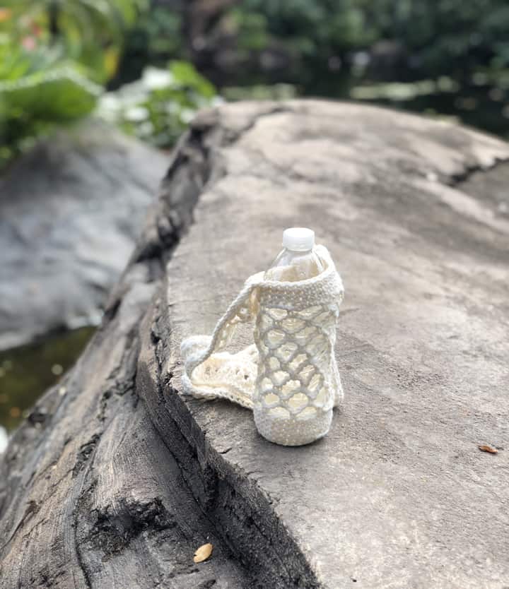 Water bottle in crochet holder on rock