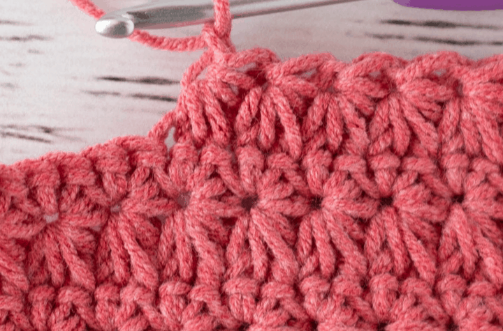 crochet stitch sample of star stitch in coral color yarn