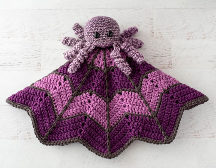 crochet spider on a light and dark purple crochet lovey blanket