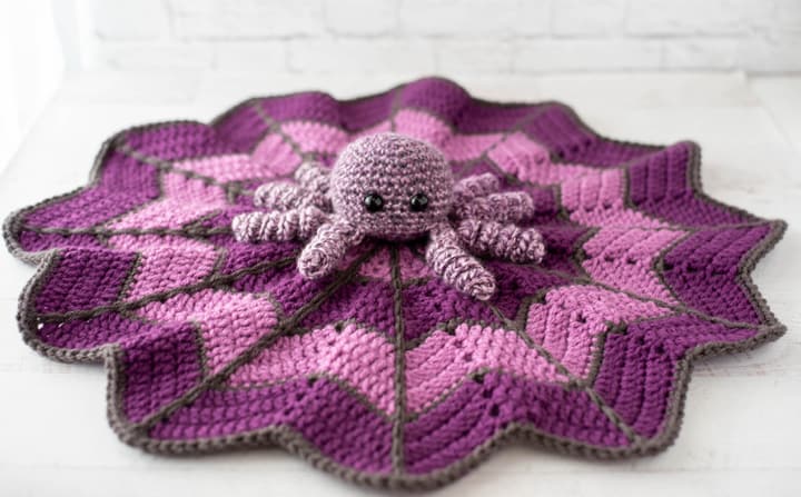 crochet spider on a light and dark purple crochet lovey blanket