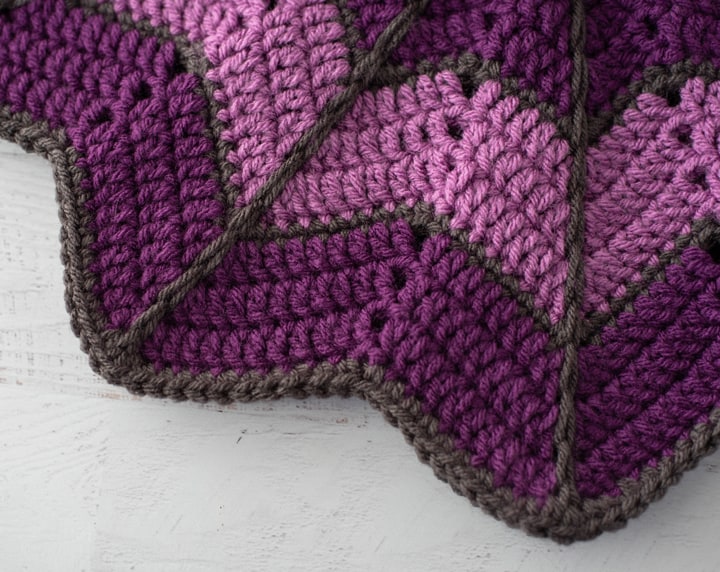 edge of purple blanket with dark gray trim