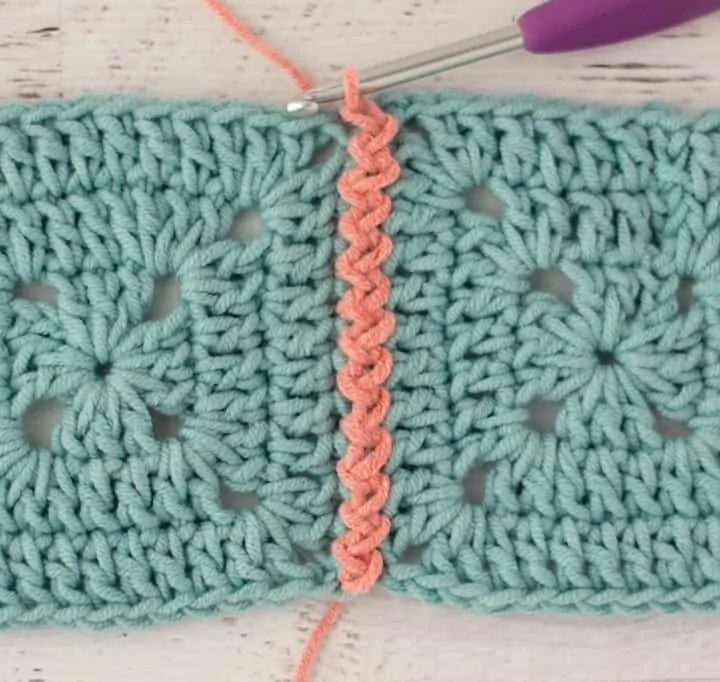 blue crochet granny squares with pink zig zag slip stitch join