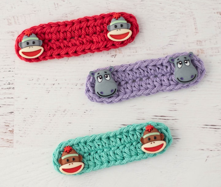Red, Purple and Green crochet ear savers with monkey and hippo buttons