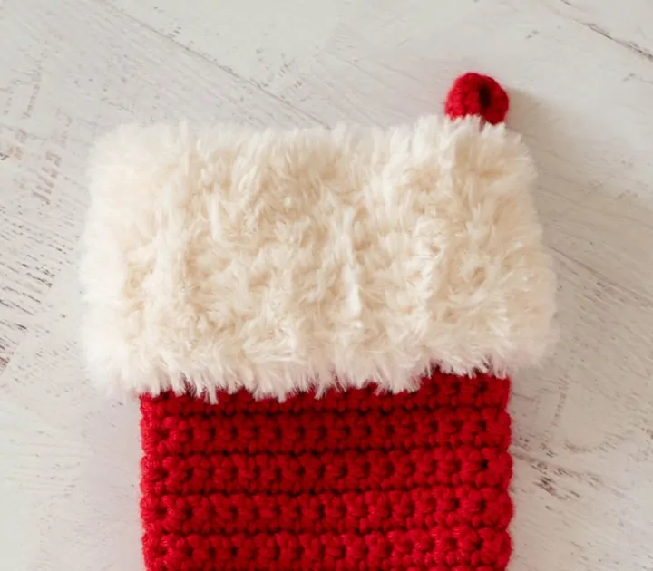 A red crochet stocking with a white cuff.