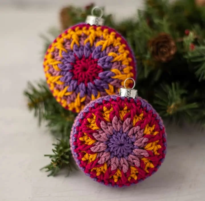 crochet ornaments in jewel tone purple, pink and gold yarn.