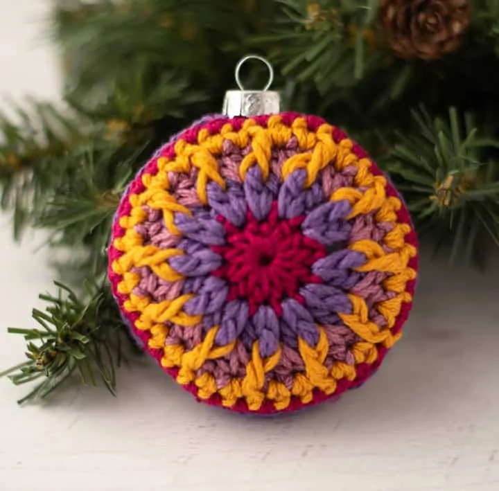 crochet ornaments in jewel tone purple, pink and gold yarn.