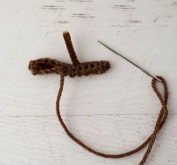 sewing needle, brown fabric over brown pipe cleaner