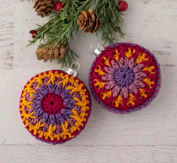 crochet ornaments in jewel tone purple, pink and gold yarn.