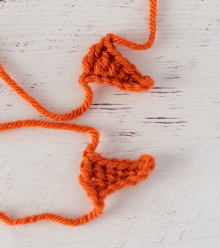 two orange crochet triangles