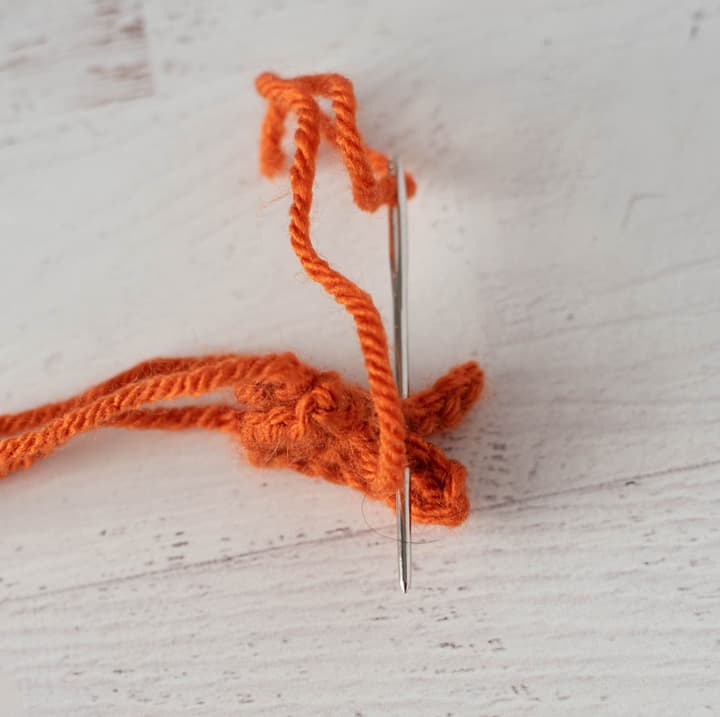 Sewing together orange crochet pieces