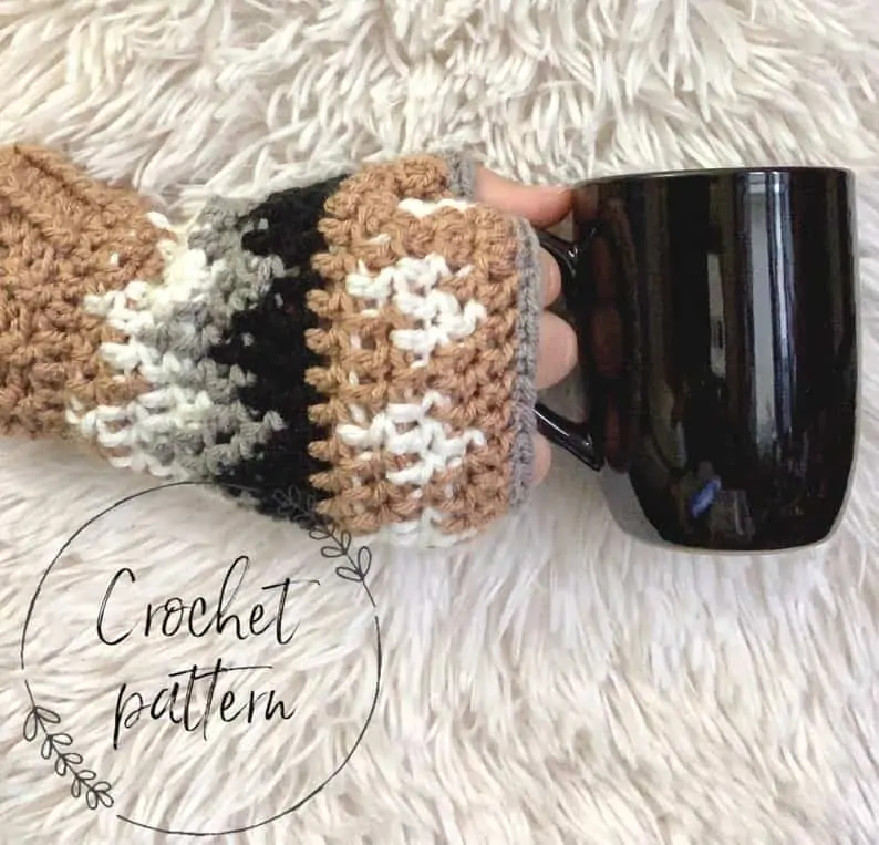 gold, brown and white crochet fingerless gloved hand holding coffee mug