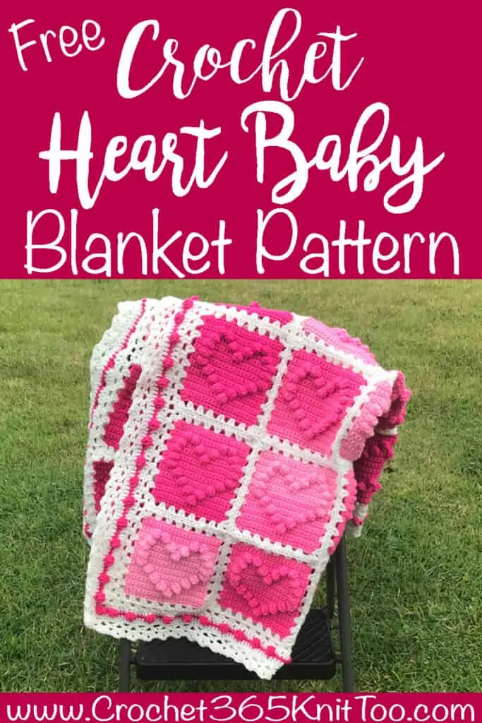 crochet afghan with pink heart squares and a white lacy like border