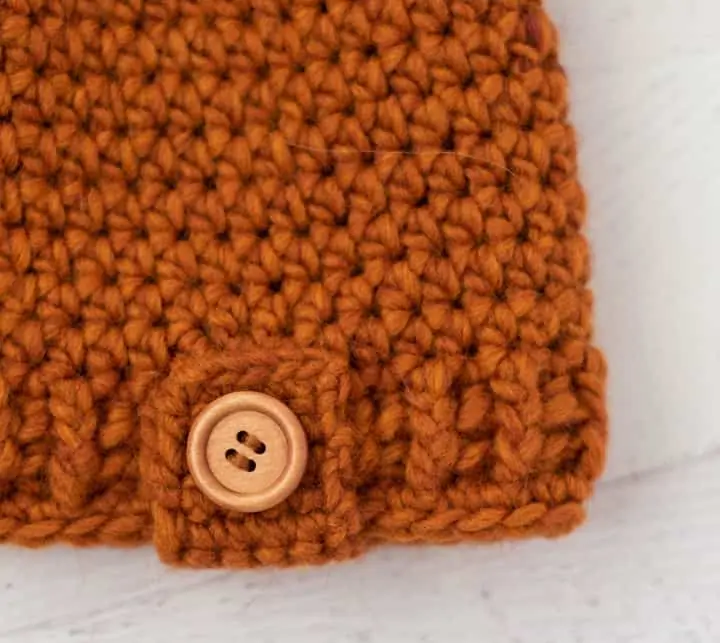 Close up of rust color crochet and wood button