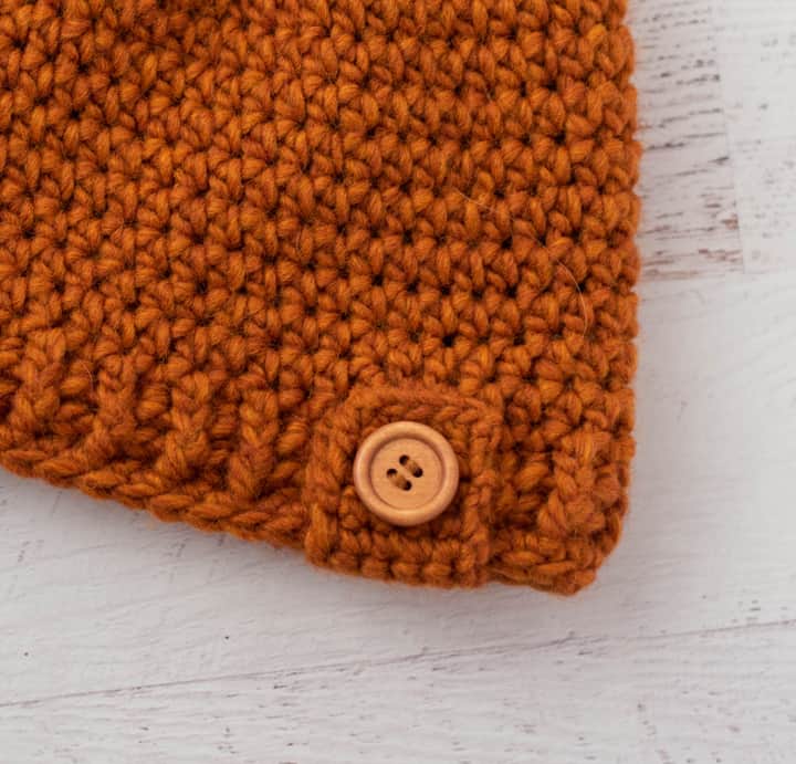 close up of rust color crochet and wood button