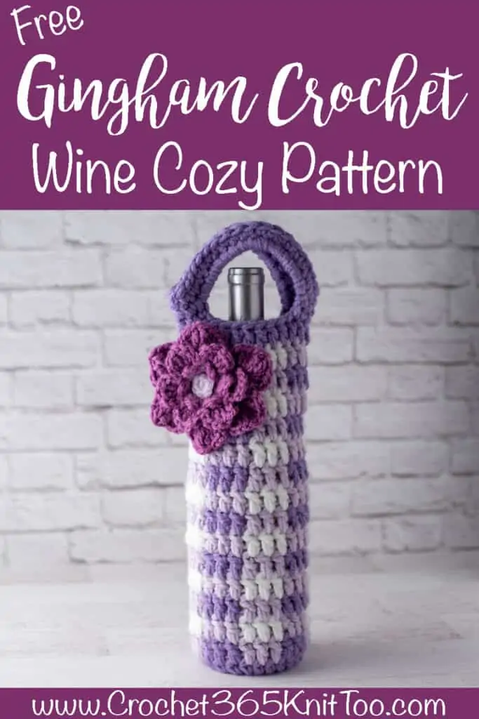 Image of Gingham Crochet Wine Cozy in dark and light purple and white with bright pink flower