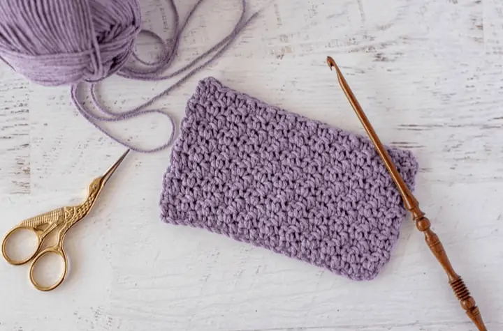 Crochet purple fabric with wood crochet hook and gold scissors