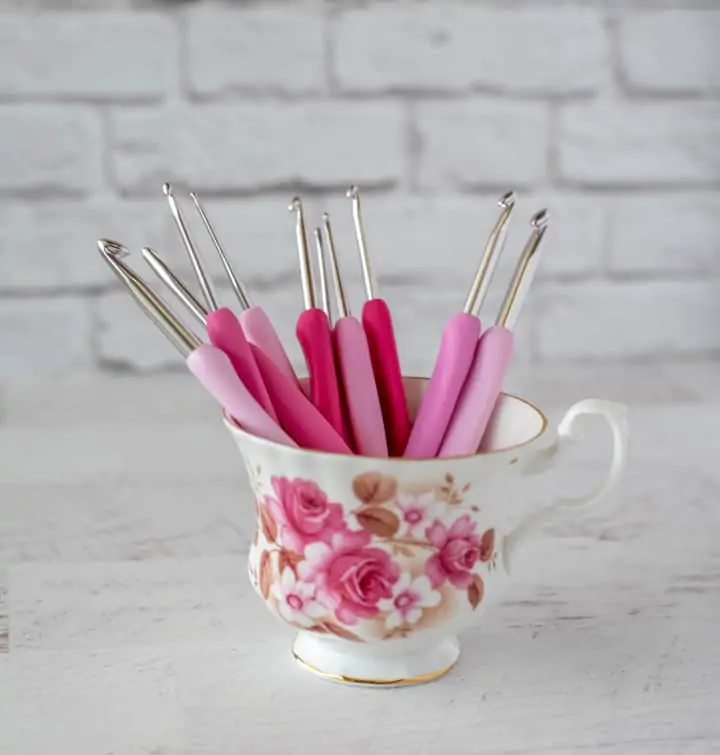 pink crochet hooks in teacup